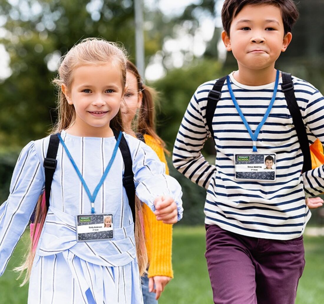 two children walking to their school wearing their school badge